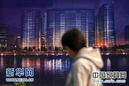 一位市民從杭州市區的一處商業樓盤廣告牌前走過（2010年11月4日攝）。新華社記者 黃宗治 攝 